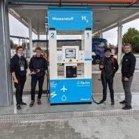 Schülergruppe an Wasserstoff-Tankstelle bei Exkursion