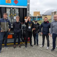 Team vor Fahrzeug auf dem Schulhof